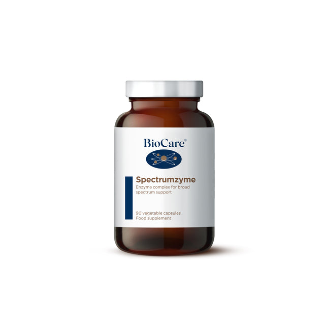 A close-up of BioCare Spectrumzyme (Enzyme Complex) capsules, showing 90 vegetarian capsules in a clear container designed for digestive support, containing enzymes like Bromelain, Papain, Protease, Lipase, Amylase, Gluten Protease, and Lactase to aid in the digestion of fats, proteins, carbohydrates, and gluten