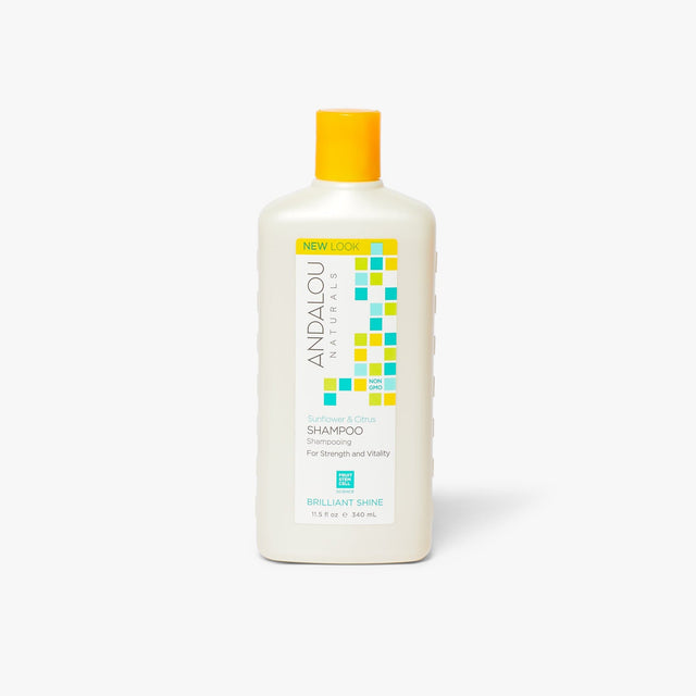 A 340ml bottle of Andalou Sunflower & Citrus Brilliant Shine Shampoo, featuring vibrant packaging with images of sunflowers and citrus fruits, designed to nourish, brighten, and add shine to normal, coloured, and frizzy hair using natural ingredients like sunflower oil, citrus extracts, and fruit stem cells