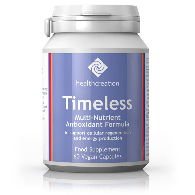 A close-up of a bottle of Health Creation Timeless capsules containing acetyl L-carnitine, alpha lipoic acid, rosemary, Ginkgo biloba, and CoQ10 supplements, with some capsules spilled nearby on a white background