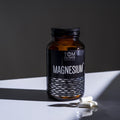 An image showing the supplement packaging of Tom Oliver Magnesium Taurate - 60 capsules, highlighting its eco-friendly, recyclable glass bottle