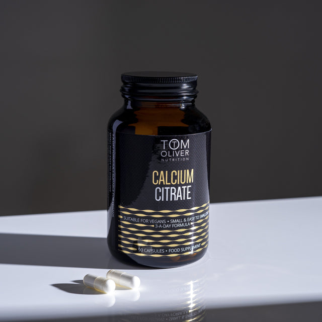 Close-up of Tom Oliver Calcium Citrate 90 capsules bottle highlighting the label and capsule details