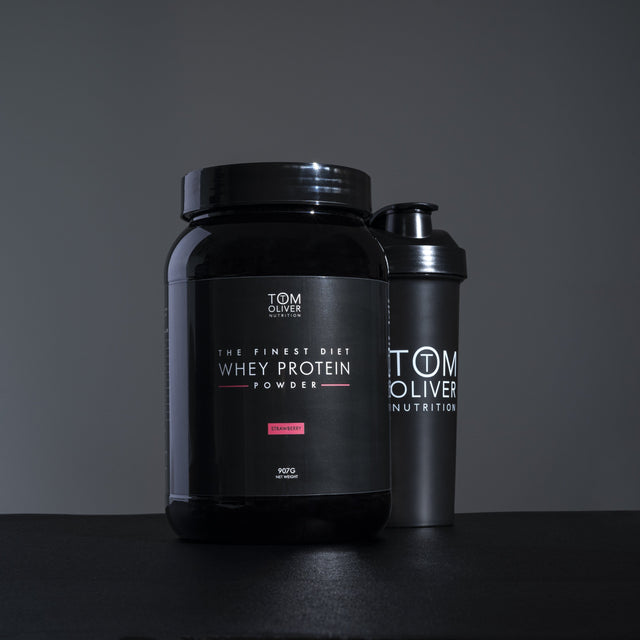 Close-up of Tom Oliver Diet Whey Strawberry 907g tub highlighting label and product features