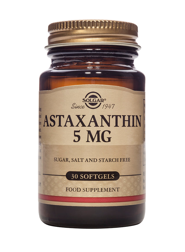 An image showing two Solgar Astaxanthin 5mg softgel capsules lying on a white surface, illustrating the product packaging and natural composition