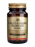 Close-up of two Solgar L-Glutathione Reduced capsules next to the product box, highlighting the supplement's packaging