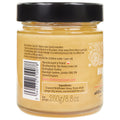 Close-up of the Honey Lovers Honeyboost Ginger & Lemon Honey with visible ginger and lemon pieces mixed within the honey
